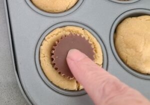 push mini peanut butter cups into cookies