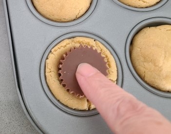 push mini peanut butter cups into cookies